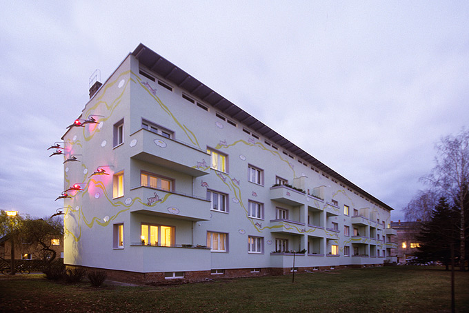 Robert Conrad: »Block 3 von Südosten gesehen, nach der Sanierung, beleuchtete Fassaden, Kunst am Bau: Sergej Dott, Berlin, Bilddokumentation für den Bauträger«, Bild aus der Serie »Sanierung einer Wohnsiedlung in Berlin Weißensee, DE«