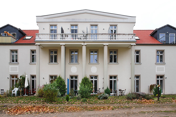 Robert Conrad: »Ehemaliges Kasernengebäude nach Umbau zur Wohnanlage, Hauptfassade mit neuem, frei entworfenem Frontispiz und Säulenvorbau, Blick von Süden, Bilddokumentation für die Entwicklungsgesellschaft«, Bild aus der Serie »Wohnanlage in Fürstenberg, 
Land Brandenburg, DE,«